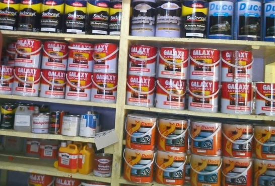 Shelves stocked with Galaxy, Duco and Sadolin automotive paint tins