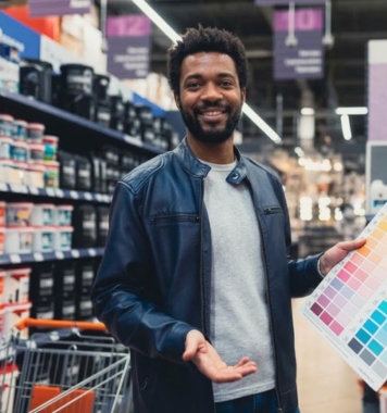 Smiling store assistant holding a colour chart in a paint shop